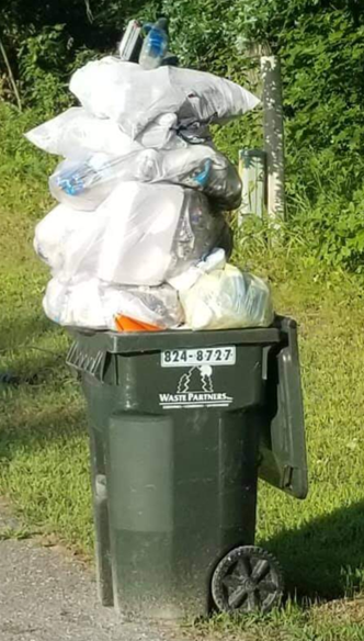 Overfilled green trash bin with bags stacked above the lid on a sidewalk; Waste Partners logo visible on the bin.